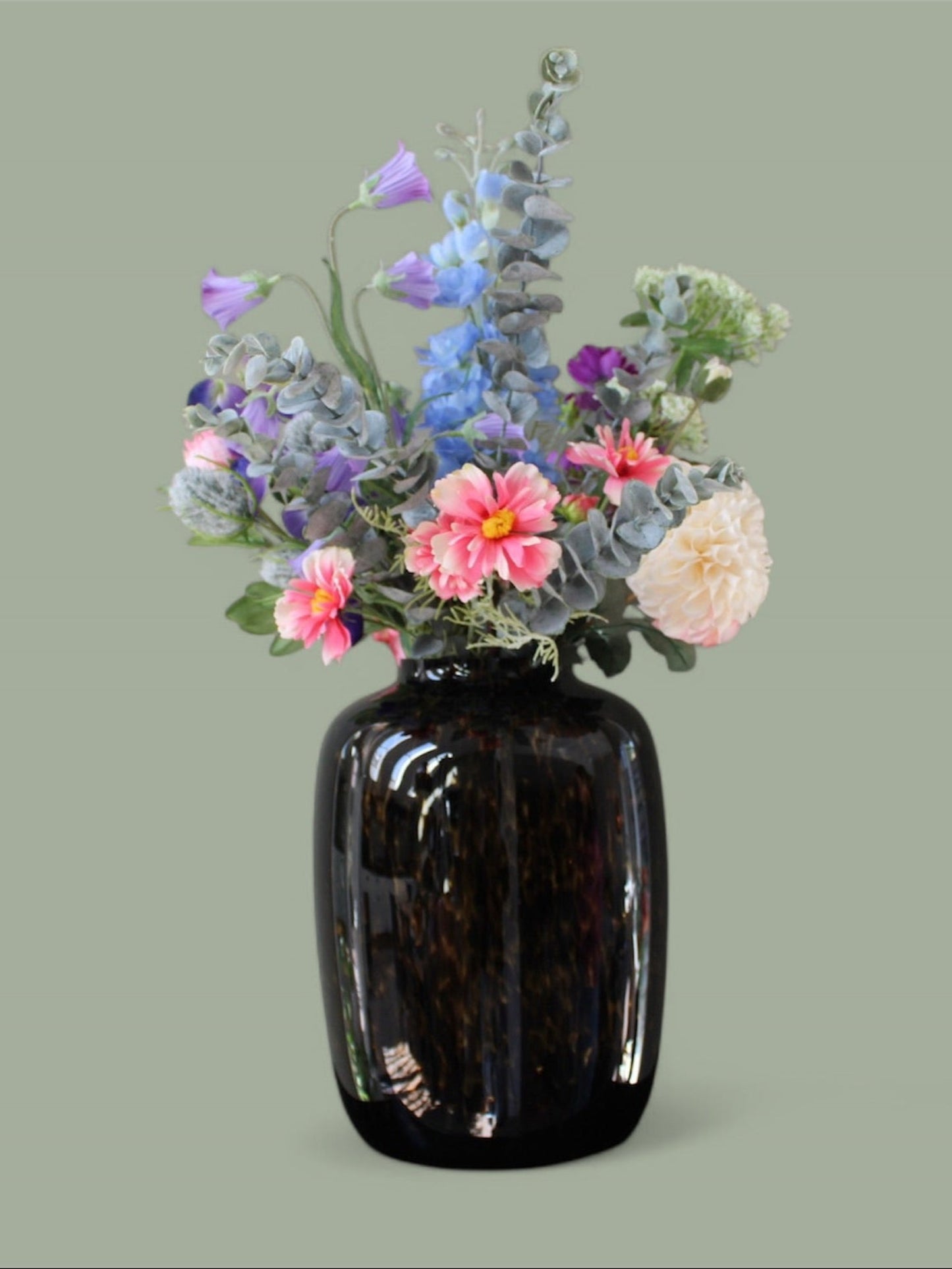 Close up Zijden plakboeket met roze, paarse, blauwe, witte bloemen met vaas met cheetah dieren print