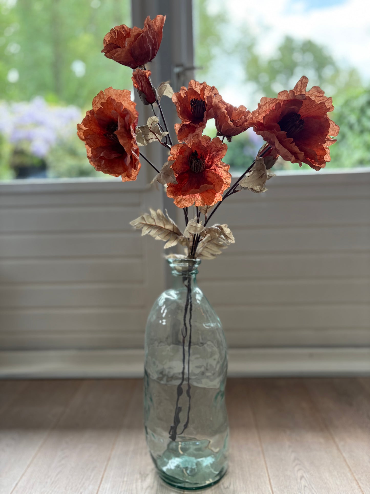 Zijden klaproos oranje in een glazen vaas