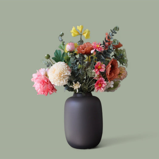 Zijden plukboeket Nikki met een dahlia, pioenroos en oranje poot in een mat zwarte vaas