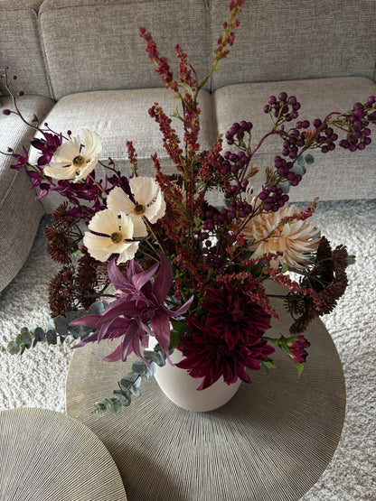 Close up Zijden boeket met diep bordeaurode en paarse tinten in een invoorkleurige vaas van 35 cm hoog
