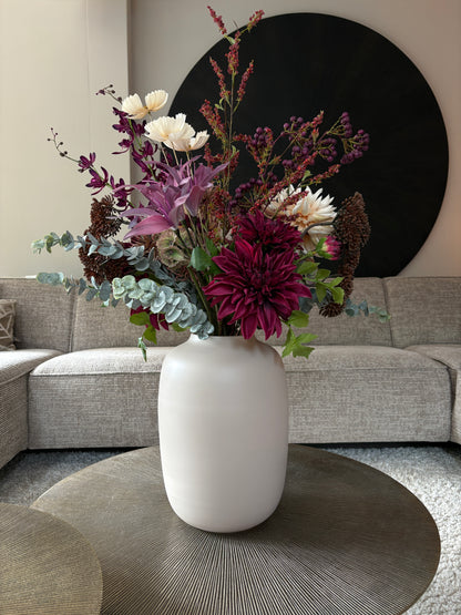 Zijden boeket met diep bordeaurode en paarse tinten in een invoorkleurige vaas van 35 cm hoog