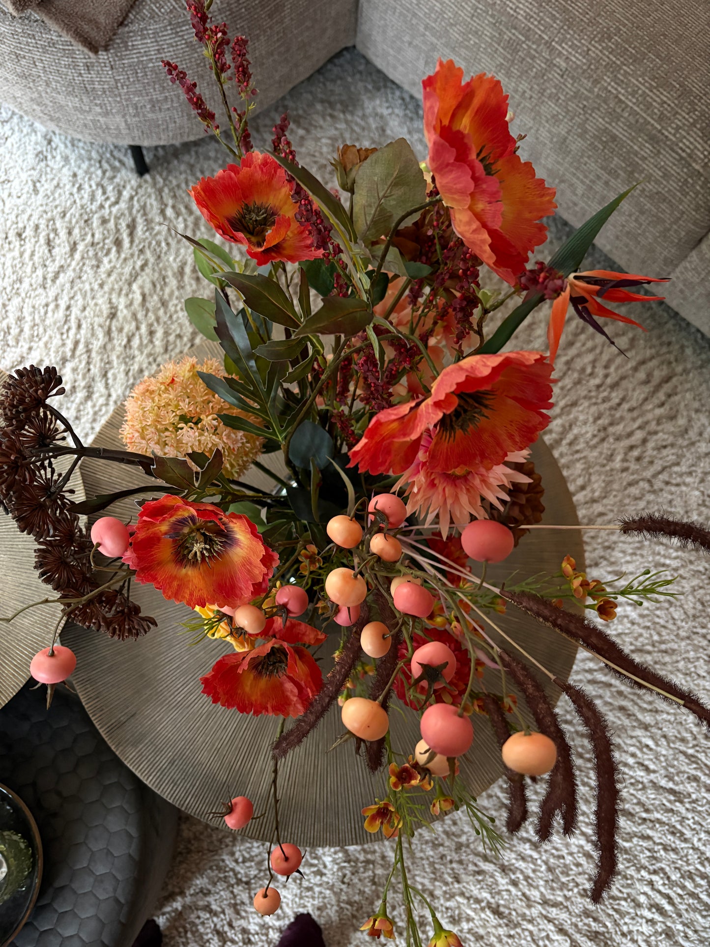 Close up Zijden boeket Saar met 14 stelen in warme herfsttinten geel, oranje en paars, stijlvol geschikt in een cheetah print vaas van 29 cm hoog.

