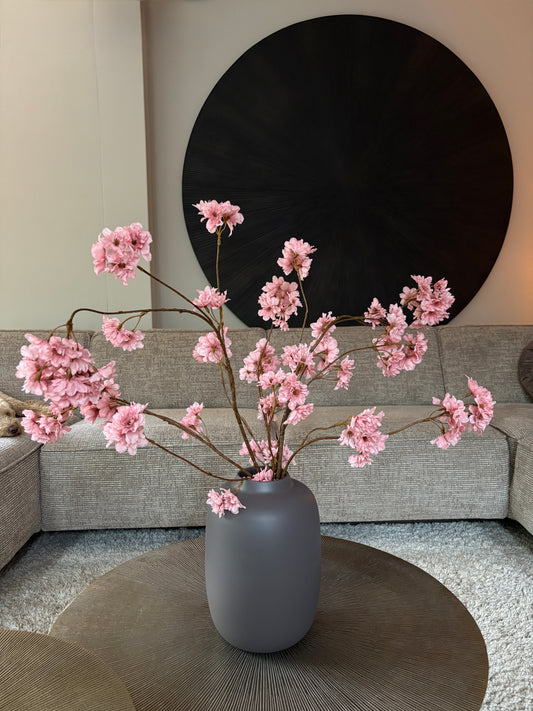 Zijden prunustak in taupe tint met verfijnde bloesems in een earth vaas van 29 cm hoog. Perfect als stijlvolle decoratie of aanvulling op een zijden boeket.