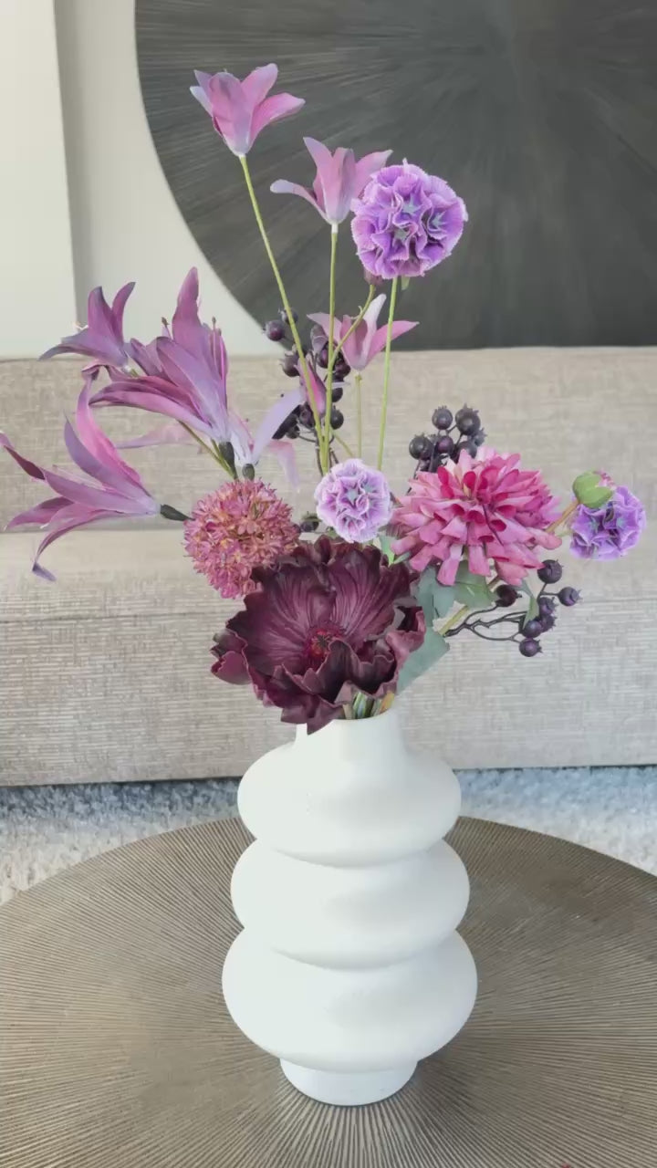 Video: Boeket Fee is een compact maar stijlvol zijden boeket met 6 paarse bloemen van hoogwaardige kwaliteit, waaronder een anemoon, scabiosa en dahlia. Een speels en elegant geheel.